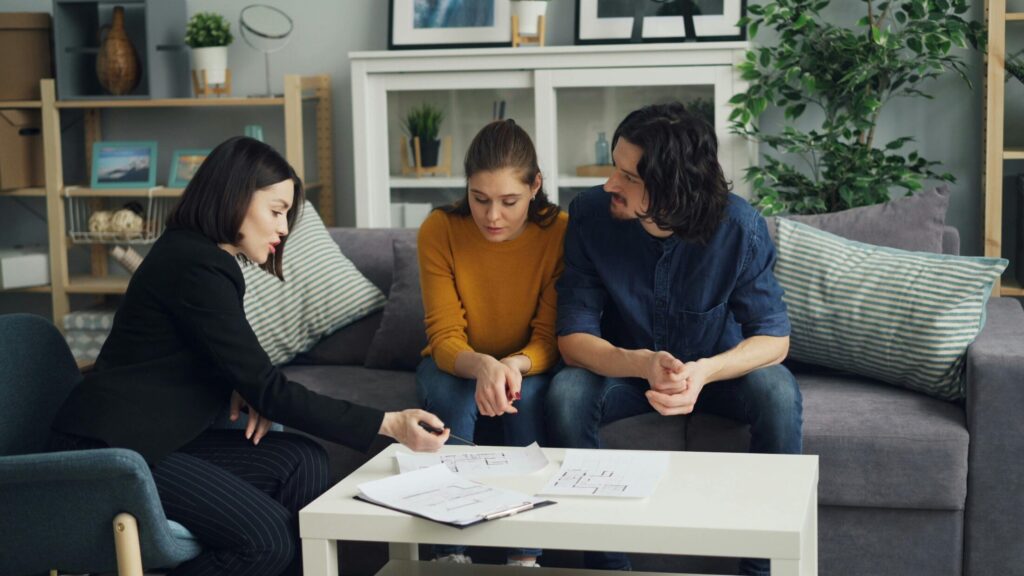 a couple and real estate agent sitting inside the house
